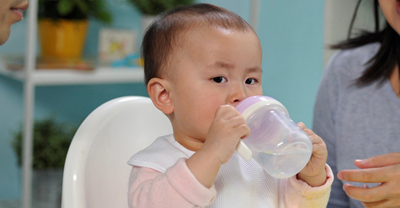 Help babies drink from a cup.